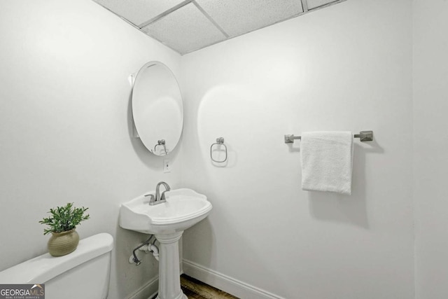 5421 Amherst Way, Flowery Branch, GA 30542 - half bath with a drop ceiling, toilet, baseboards, and wood finished floors