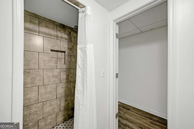 5421 Amherst Way, Flowery Branch, GA 30542 - full bathroom with tiled shower, wood finished floors, baseboards, and a paneled ceiling