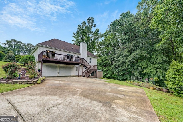 5421 Amherst Way, Flowery Branch, GA 30542 - back of house featuring stairs, a chimney, a deck, concrete driveway, and an attached garage