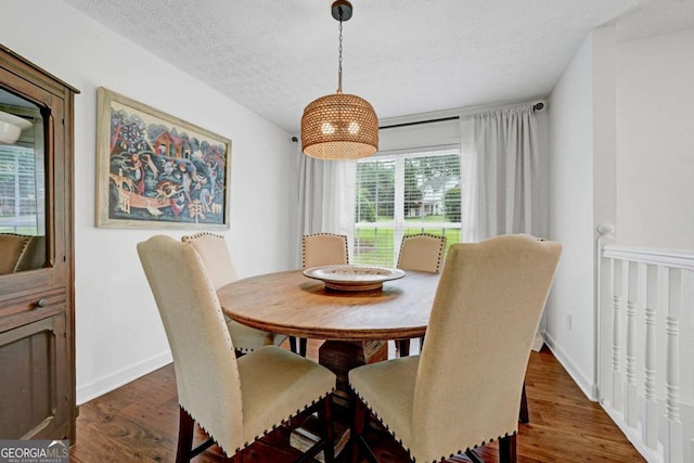 5421 Amherst Way, Flowery Branch, GA 30542 - dining area with wood finished floors, a textured ceiling, and baseboards