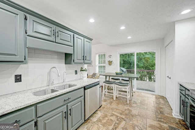 5421 Amherst Way, Flowery Branch, GA 30542 - kitchen with stainless steel dishwasher, a sink, decorative backsplash, recessed lighting, and gray cabinetry