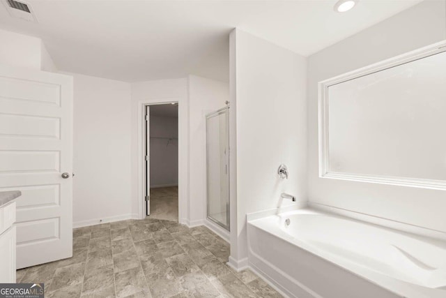 12085 Conrad Cir, Hampton, GA 30228 - bathroom with a stall shower, a bath, a walk in closet, and recessed lighting