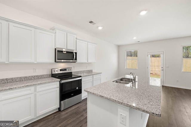 12085 Conrad Cir, Hampton, GA 30228 - kitchen with stainless steel appliances, white cabinets, dark wood-type flooring, a kitchen island with sink, and recessed lighting