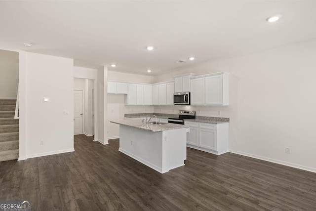12085 Conrad Cir, Hampton, GA 30228 - kitchen featuring appliances with stainless steel finishes, white cabinetry, dark wood finished floors, an island with sink, and recessed lighting