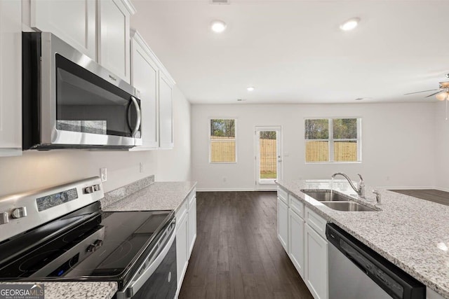 12085 Conrad Cir, Hampton, GA 30228 - kitchen with appliances with stainless steel finishes, dark wood-style flooring, white cabinets, light stone counters, and recessed lighting