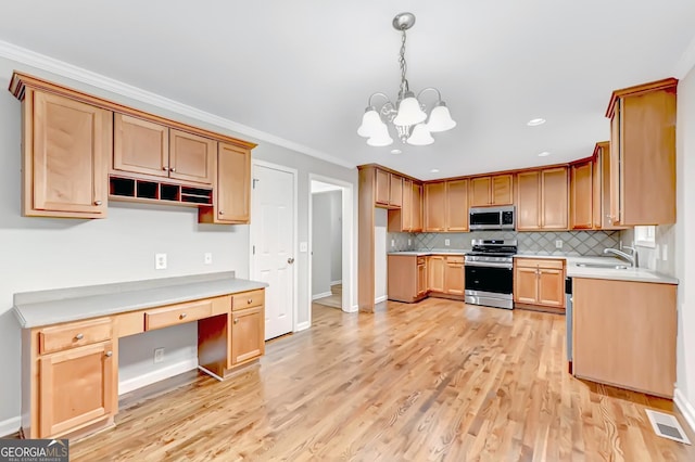 327 Oakland Bay Ct, Loganville, GA 30052 - kitchen featuring stainless steel appliances, crown molding, a sink, a chandelier, and light wood-style flooring