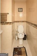 1405 Overland Xing, Alpharetta, GA 30004 - bathroom featuring tile walls, toilet, and a wainscoted wall