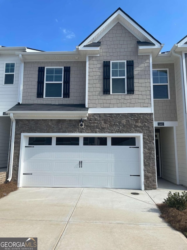 1311 Aura Ln, Lawrenceville, GA 30045 - view of front of home featuring a garage, concrete driveway, and stone siding