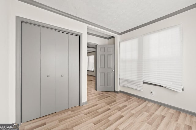 2110 Newnan St, Atlanta, GA 30344 - unfurnished bedroom featuring light wood-style flooring, a closet, and a textured ceiling