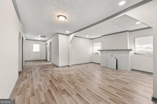 2110 Newnan St, Atlanta, GA 30344 - unfurnished living room with crown molding, a textured ceiling, wood finished floors, recessed lighting, and a brick fireplace