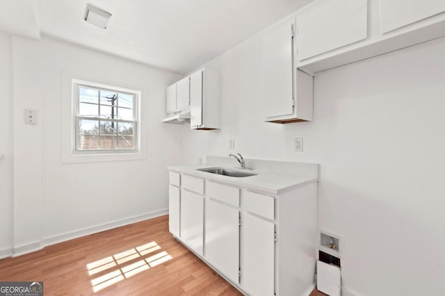 2110 Newnan St, Atlanta, GA 30344 - kitchen featuring light wood-style flooring, white cabinetry, and light countertops