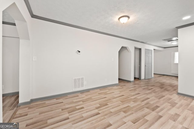 2110 Newnan St, Atlanta, GA 30344 - unfurnished living room with crown molding, light wood finished floors, arched walkways, a textured ceiling, and recessed lighting