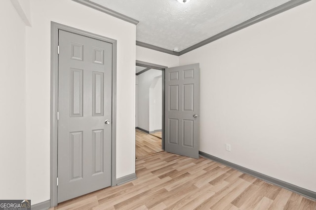 2110 Newnan St, Atlanta, GA 30344 - unfurnished bedroom featuring light wood-style flooring, crown molding, and a textured ceiling