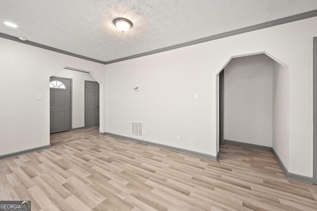 2110 Newnan St, Atlanta, GA 30344 - empty room featuring arched walkways, light wood-style flooring, a textured ceiling, ornamental molding, and recessed lighting