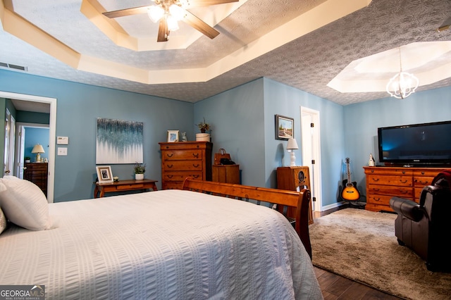 1612 Cagle Ct, Lawrenceville, GA 30045 - bedroom with a tray ceiling, wood finished floors, a ceiling fan, and a chandelier