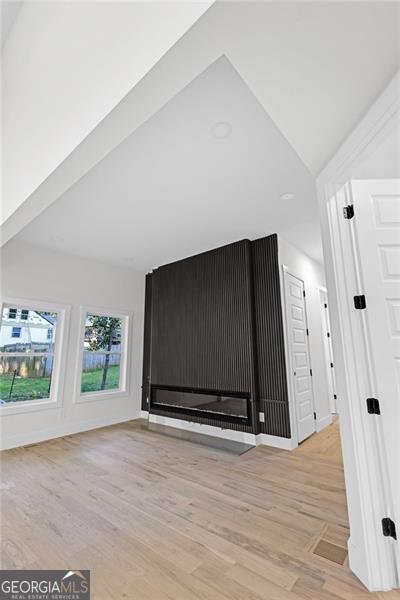 2764 Midway Rd, Decatur, GA 30030 - unfurnished living room with light wood finished floors and vaulted ceiling