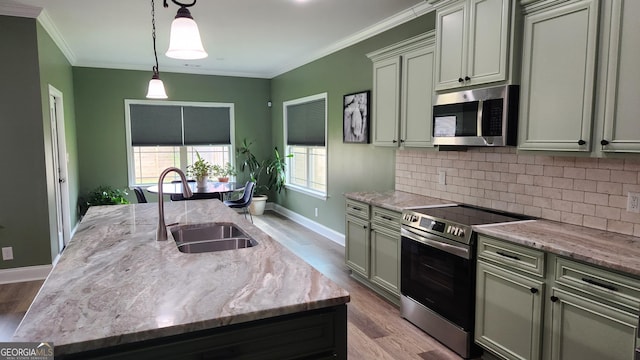 556 Constitution Dr, Forsyth, GA 31029 - kitchen featuring stainless steel appliances, a sink, a kitchen island with sink, backsplash, and wood finished floors