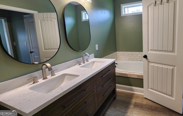 556 Constitution Dr, Forsyth, GA 31029 - bathroom featuring double vanity, a bath, and wood finished floors