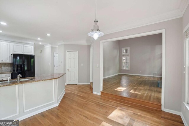 220 Chinkapin Cir SW, South Fulton, GA 30311 - kitchen with black fridge with ice dispenser, crown molding, light wood finished floors, white cabinetry, and recessed lighting