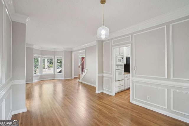 220 Chinkapin Cir SW, South Fulton, GA 30311 - spare room featuring a decorative wall, ornamental molding, stairway, and light wood-style floors