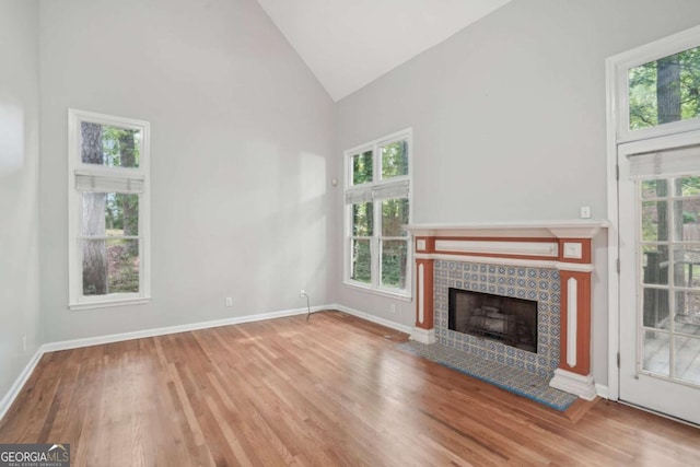 220 Chinkapin Cir SW, South Fulton, GA 30311 - unfurnished living room with high vaulted ceiling, plenty of natural light, wood finished floors, and a tile fireplace