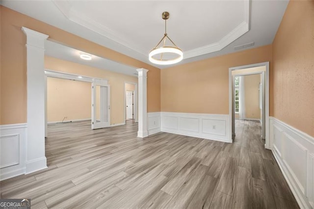 5156 Amberden Hall Dr, Suwanee, GA 30024 - unfurnished room featuring decorative columns, a raised ceiling, a decorative wall, wood finished floors, and wainscoting