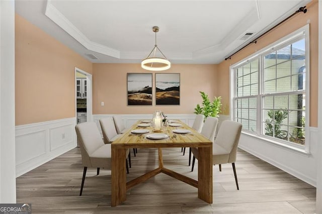 5156 Amberden Hall Dr, Suwanee, GA 30024 - dining room featuring crown molding, a tray ceiling, a wainscoted wall, wood finished floors, and a decorative wall