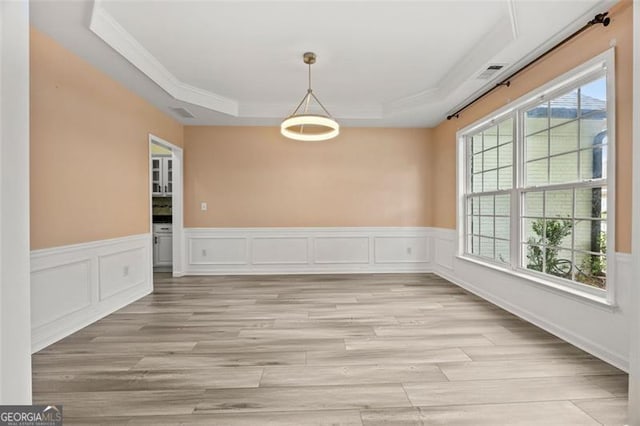 5156 Amberden Hall Dr, Suwanee, GA 30024 - unfurnished dining area featuring crown molding, a tray ceiling, light wood-style flooring, and wainscoting