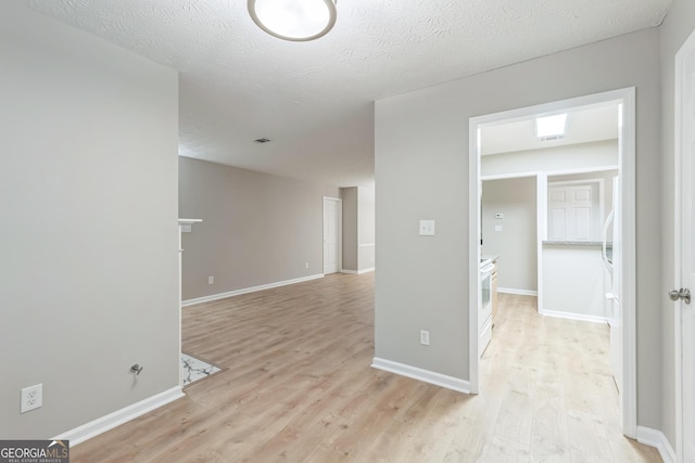 1005 Peachtree Forest Ter, Peachtree Corners, GA 30092 - empty room featuring light wood-style floors, baseboards, and a textured ceiling