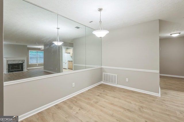 1005 Peachtree Forest Ter, Peachtree Corners, GA 30092 - unfurnished dining area featuring wood finished floors, baseboards, a textured ceiling, and a premium fireplace