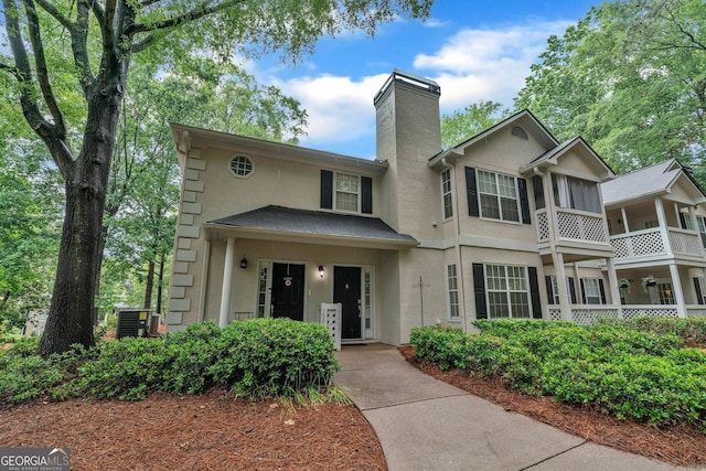1005 Peachtree Forest Ter, Peachtree Corners, GA 30092 - view of front of house with stucco siding, a chimney, and central AC unit