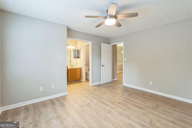 1005 Peachtree Forest Ter, Peachtree Corners, GA 30092 - unfurnished bedroom featuring light wood-style floors, baseboards, a sink, and a textured ceiling