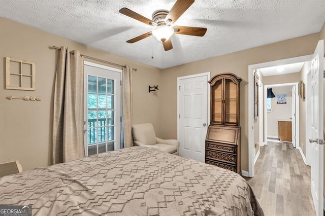 6504 Samoa, Flowery Branch, GA 30542 - bedroom featuring light wood finished floors, a textured ceiling, baseboards, and ceiling fan