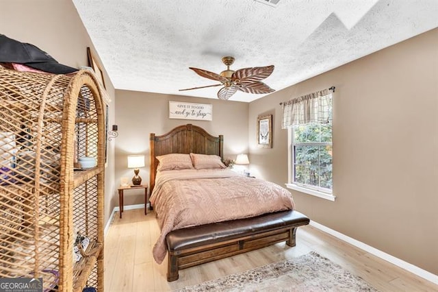 6504 Samoa, Flowery Branch, GA 30542 - bedroom featuring a textured ceiling, light wood-style flooring, baseboards, and ceiling fan