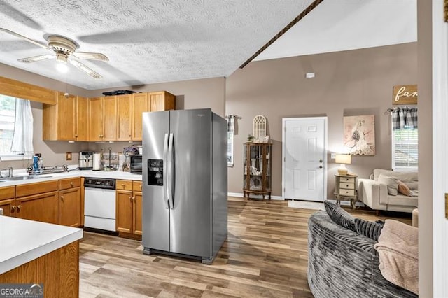 6504 Samoa, Flowery Branch, GA 30542 - kitchen featuring stainless steel refrigerator with ice dispenser, white dishwasher, open floor plan, light countertops, and light wood-type flooring