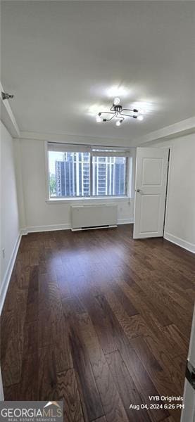 2479 Peachtree Rd NE Unit 902, Atlanta, GA 30305 - empty room with dark wood-type flooring, baseboards, and radiator