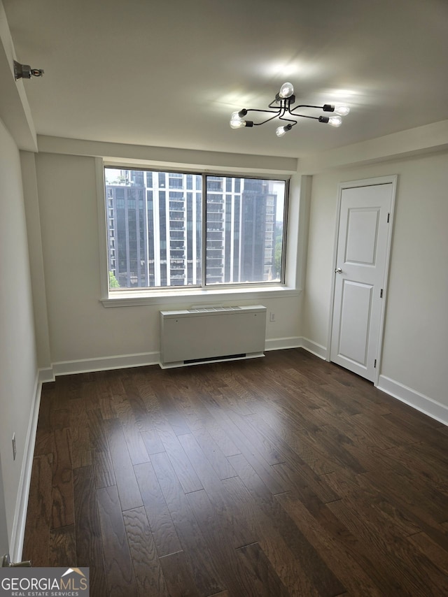 2479 Peachtree Rd NE Unit 902, Atlanta, GA 30305 - spare room featuring a chandelier, healthy amount of natural light, dark wood-style flooring, and radiator heating unit