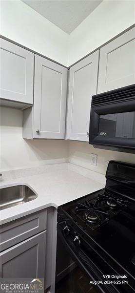 2479 Peachtree Rd NE Unit 902, Atlanta, GA 30305 - kitchen with black appliances, light countertops, and gray cabinetry