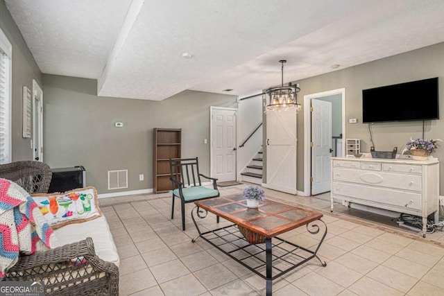 270 Meadow View Dr, Grayson, GA 30017 - living room with light tile patterned floors, a chandelier, stairs, a textured ceiling, and baseboards