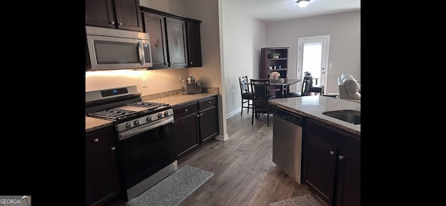 4241 Swamp Cypress Trl, Gainesville, GA 30504 - kitchen featuring appliances with stainless steel finishes, wood finished floors, and light stone countertops