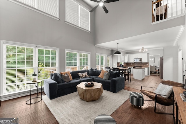 1504 Oglethorpe Dr, Suwanee, GA 30024 - living area with a high ceiling, a ceiling fan, light wood finished floors, and crown molding