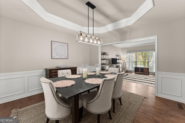1504 Oglethorpe Dr, Suwanee, GA 30024 - dining room with crown molding, wood finished floors, a wainscoted wall, a raised ceiling, and a decorative wall
