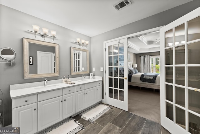 1504 Oglethorpe Dr, Suwanee, GA 30024 - ensuite bathroom featuring double vanity, wood finished floors, french doors, and ornamental molding