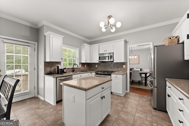 1504 Oglethorpe Dr, Suwanee, GA 30024 - kitchen with appliances with stainless steel finishes, a chandelier, white cabinetry, backsplash, and ornamental molding