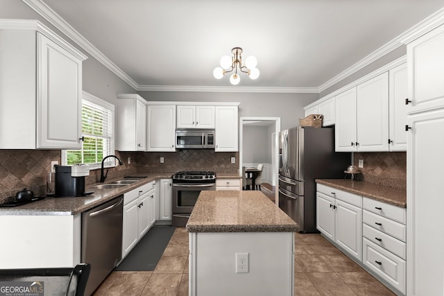 1504 Oglethorpe Dr, Suwanee, GA 30024 - kitchen featuring stainless steel appliances, ornamental molding, white cabinets, a kitchen island, and backsplash