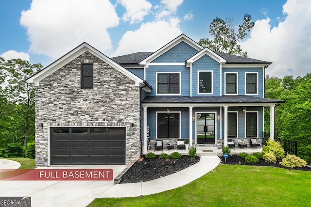 5490 Bent Grass Way, Douglasville, GA 30135 - view of front of home with covered porch, stone siding, a front lawn, driveway, and a garage