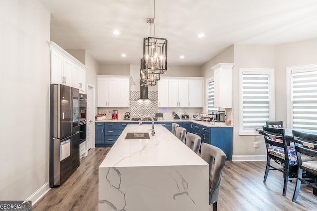 5490 Bent Grass Way, Douglasville, GA 30135 - kitchen with blue cabinetry, smart refrigerator, an island with sink, baseboards, and backsplash