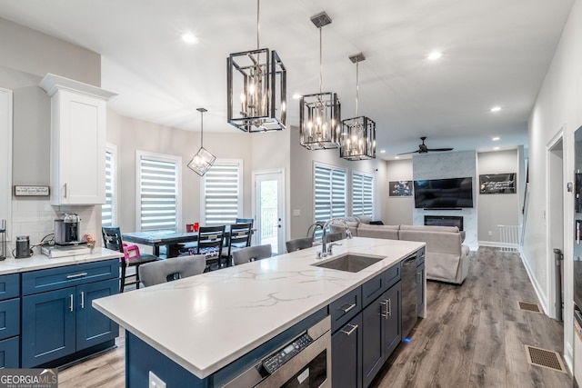 5490 Bent Grass Way, Douglasville, GA 30135 - kitchen featuring a sink, a ceiling fan, white cabinets, open floor plan, and light wood finished floors