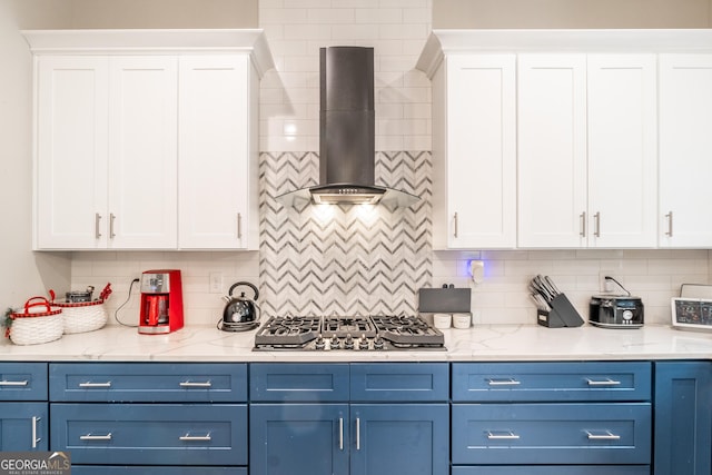 5490 Bent Grass Way, Douglasville, GA 30135 - kitchen featuring wall chimney range hood, blue cabinetry, stainless steel gas stovetop, and white cabinetry