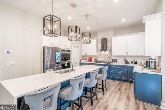 5490 Bent Grass Way, Douglasville, GA 30135 - kitchen with a sink, appliances with stainless steel finishes, blue cabinets, decorative backsplash, and wall chimney exhaust hood